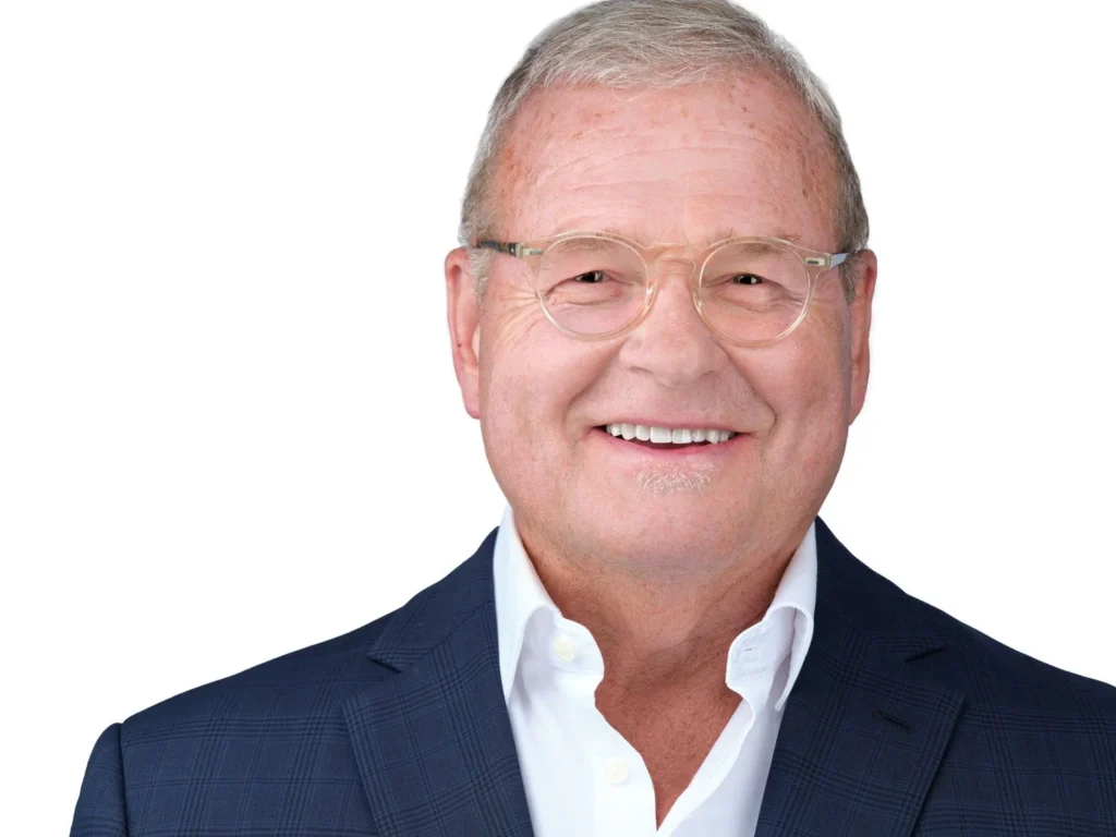 Executive headshot of a man in a navy suit and open white shirt, Toronto leadership portrait