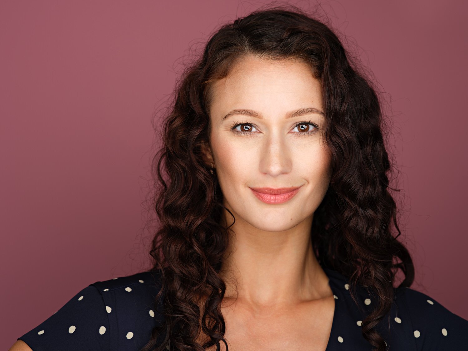 Headshot of a model in pink backdrop