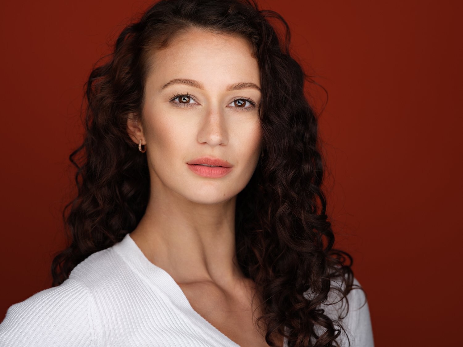 Headshot of a model in orange backdrop