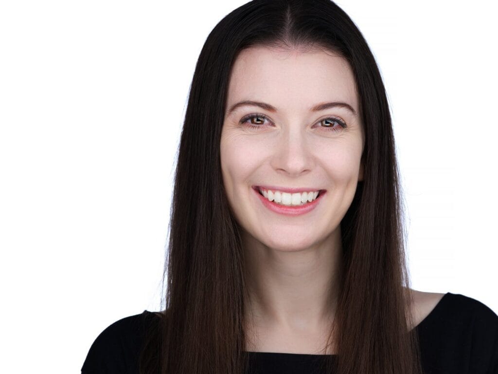 Commercial actor headshot of a woman smiling on a white background, Toronto casting session