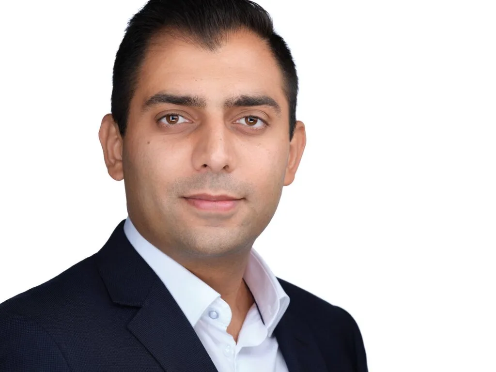 Corporate headshot of a man in a navy blazer and open collar, Toronto team session