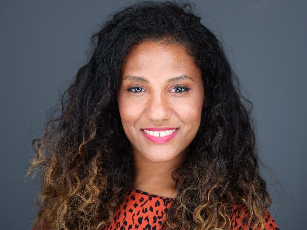 LinkedIn headshot of a woman with curly hair in a patterned top, Toronto profile photo session