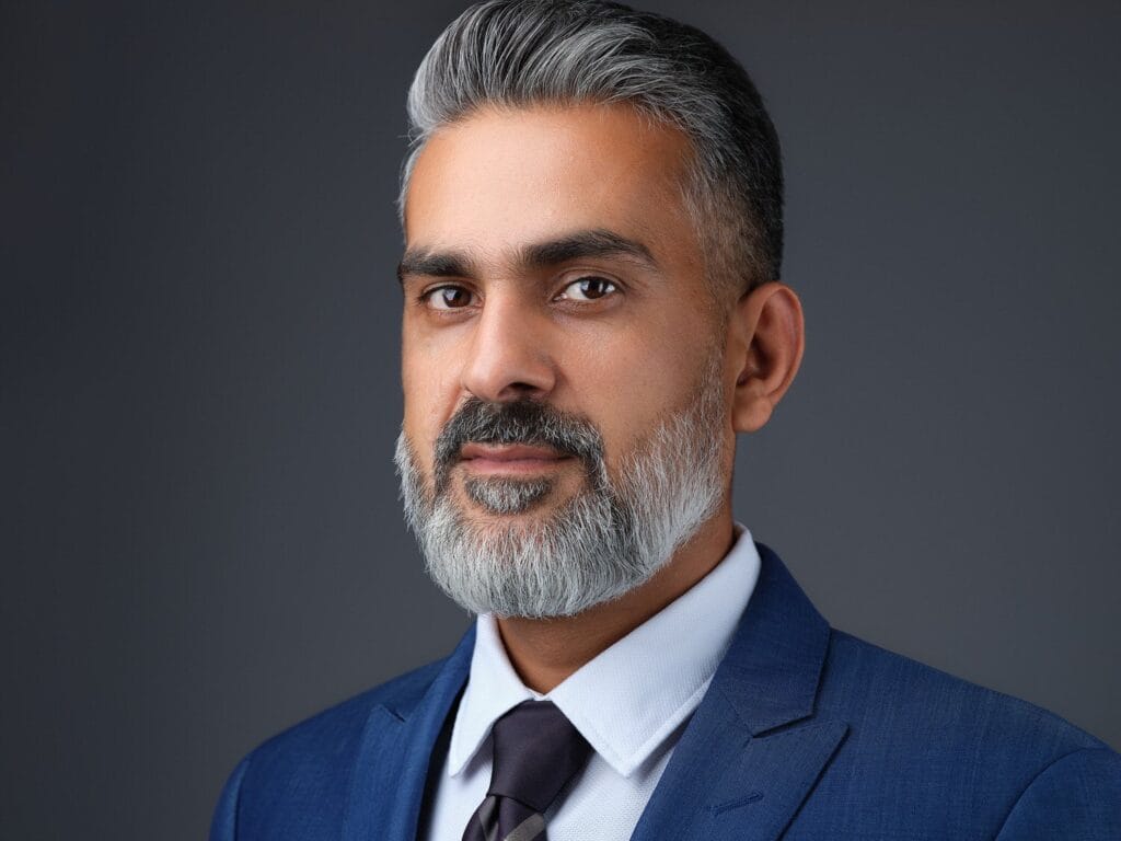 Executive headshot of a man with a grey beard in a navy suit and tie, Toronto leadership portrait
