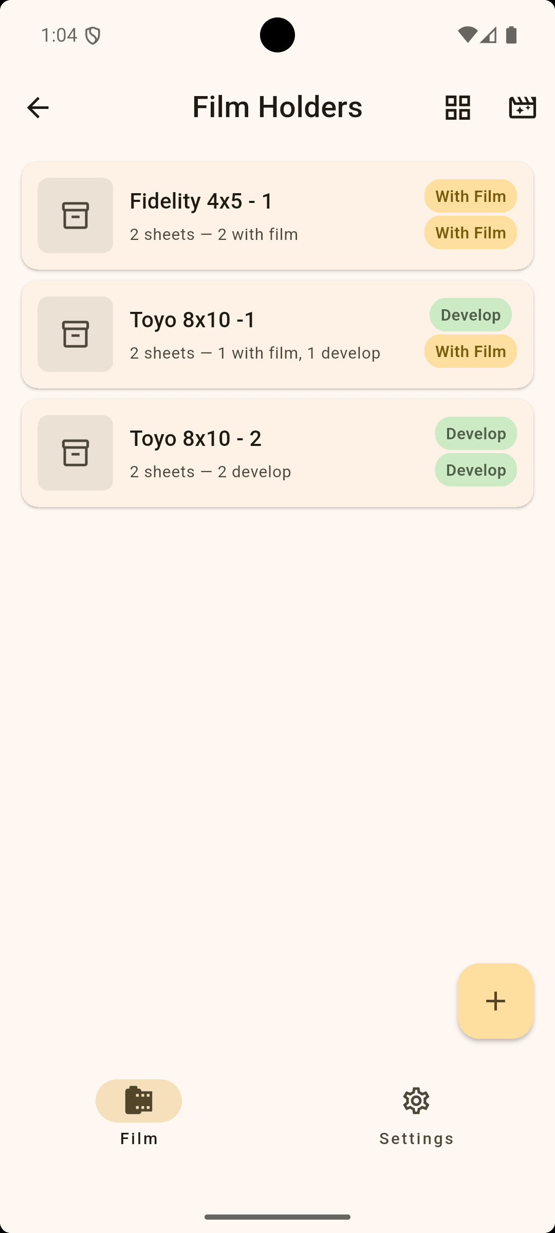 Mobile app screen showing film holders with options for developing and with film, including three different film holder items labeled Fidelity 4x5 - 1, Toyo 8x10 - 1, and Toyo 8x10 - 2. There are icons for film, settings, and a plus sign for adding new items.